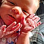 baby, newborn, infant, closeup, hands, face, pink_clothing, blue_hearts, soft_light, blanket, patterned_blanket, skin, cute, tiny_hands, portrait, child, young, resting, indoors, sleepy