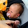 baby, pacifier, hand, finger, plush_toy, owl, car_seat, blanket, infant, person, closeup, child, cute, newborn, soft_toy, grip, face, skin, comfort, cozy