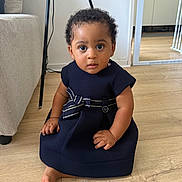 Aylee participe au concours pour gagner de l'argent avec cette photo : baby, black_hair, bow, child, curly_hair, cute, dress, floor, foot, furniture, home, indoor, light, looking_at_camera, person, portrait, sitting, small_hands, wall, wooden_floor