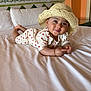 baby, bed, bedroom, child, clothing, cozy, cute, happy, hat, indoors, infant, lying_down, pillow, polka_dot, portrait, room, skin, smile, straw_hat, white_bedspread