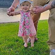 Zayla is registered to the contest to win money with this photo: baby, child, smiling, floral_dress, sun_hat, tattoos, hands, grass, lake, sunset, outdoor, nature, walking, happy, person, support, feet, summer, scenic, family