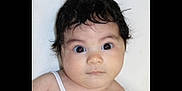 A'Va is registered to the contest to win money with this photo: baby, child, face, portrait, curious, wide_eyes, dark_hair, tank_top, innocent, candid, closeup, skin, young, person, human, expression, looking, studio, head_and_shoulders, indoor