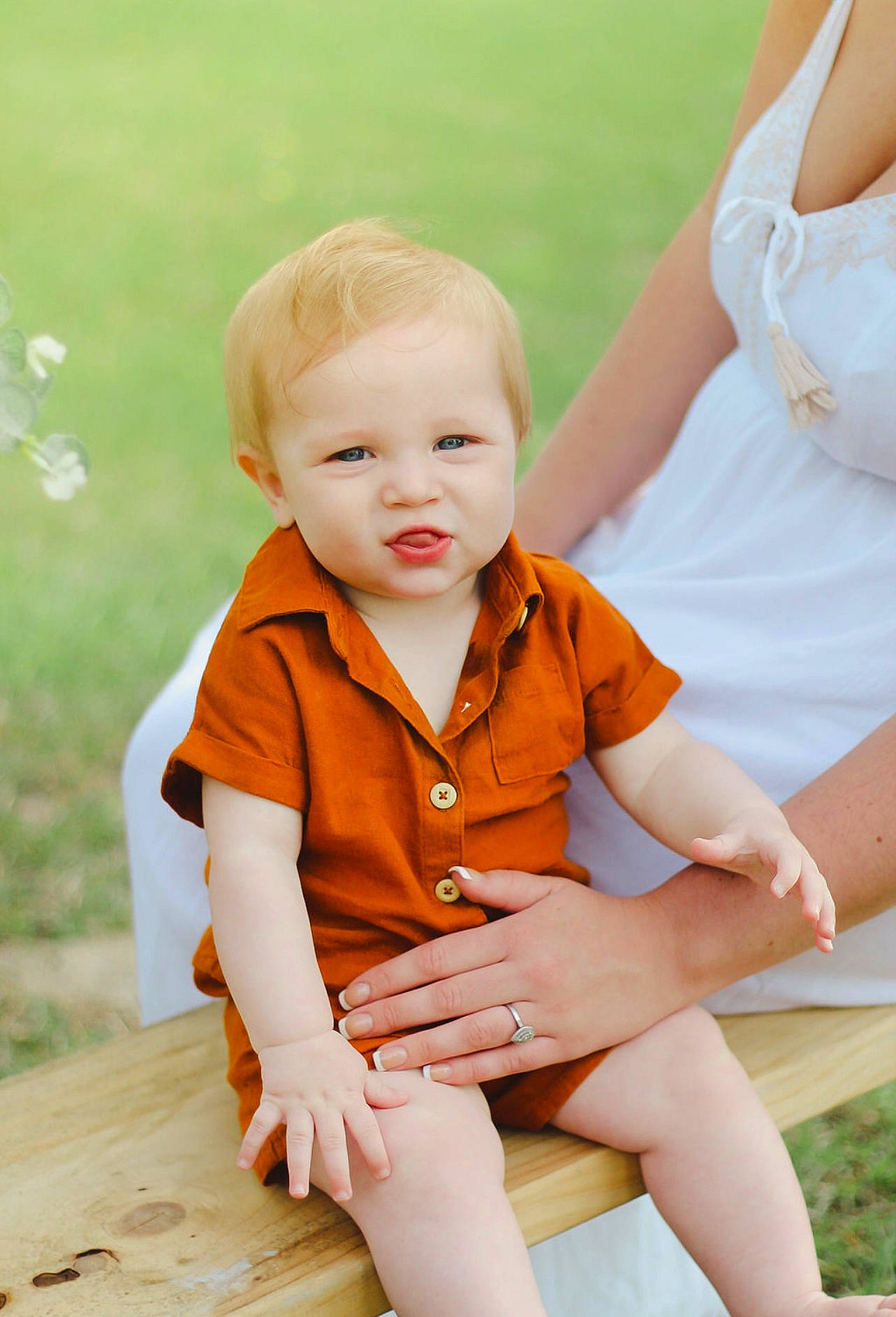 Asher is registered to the contest to win money with this photo: baby_toddler_clothing, dress, facial_expression, finger, gesture, grass, hairstyle, happy, human_body, joint, leg, leisure, orange, people_in_nature, person, shorts, skin, standing, thigh, toddler