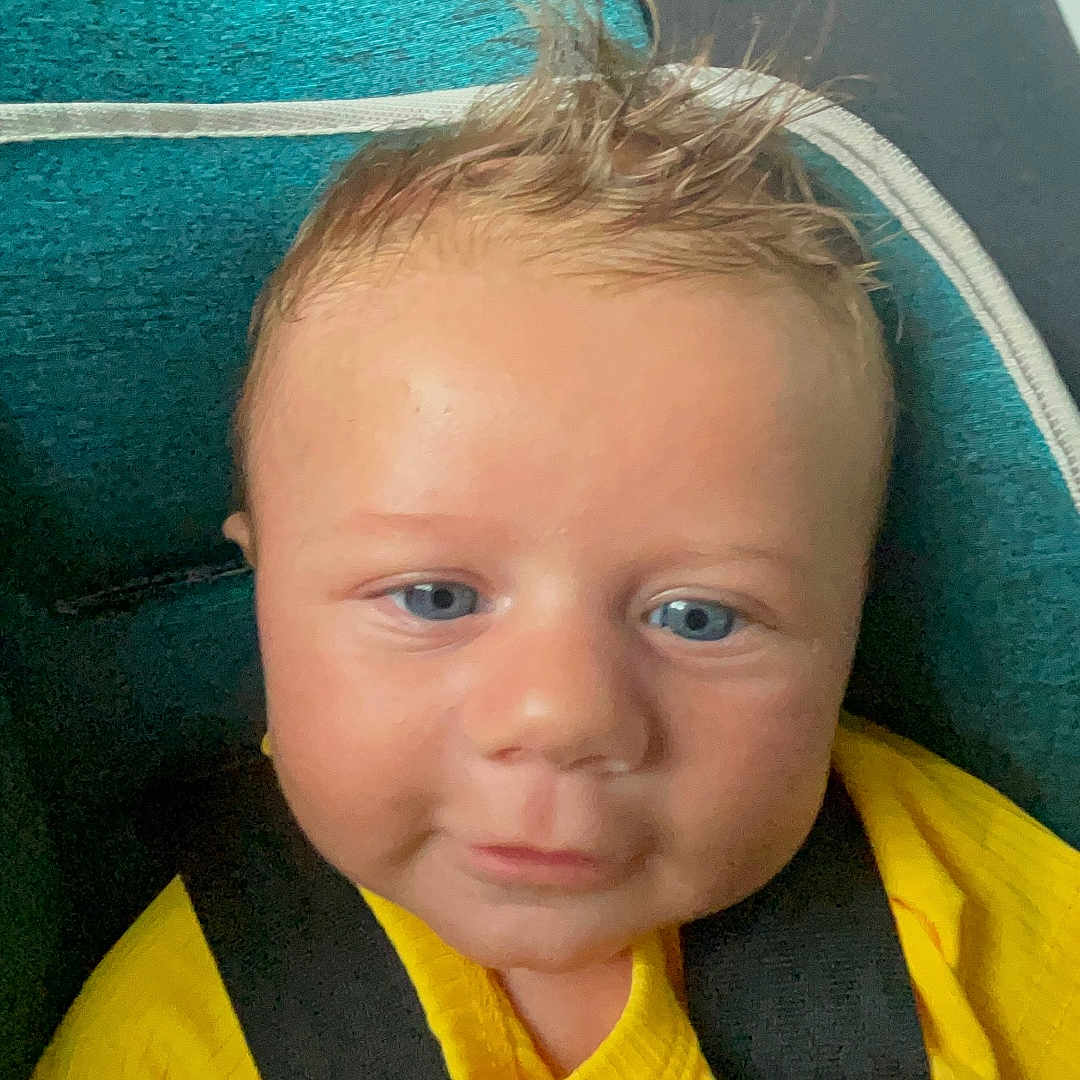 Elijah joined the competition — help win amazing prizes! baby, baby_clothing, blue_eyes, car_seat, child, child_seat, close_up, cute, face, indoor, infant, person, portrait, safety, seat, seat_belt, smile, spiky_hair, yellow_shirt, young_child
