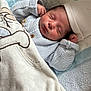 newborn, baby, sleeping, blanket, hat, sweater, cozy, infant, cute, resting, plush, soft, tucked_in, indoors, child, peaceful, face, portrait, knitted, cushion
