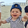 Naé a rejoint le concours — aidez-le/la à gagner de superbes lots ! toddler, child, beach, sand, smiling, cap, striped_shirt, happy, outdoor, play, summer, cute, baby, person, casual_clothing, fun, sunny, daytime, sitting, joy