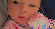 Charleigh joined the competition — help win amazing prizes! baby, child, clothing, cute, expression, face, flower, head, indoors, infant, newborn, onesie, pattern, person, portrait, rainbow, skin, soft, strawberry, warm