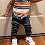 Dru joined the competition — help win amazing prizes! toddler, child, smiling, standing, door, striped_shirt, tank_top, black_pants, white_sneakers, red_stripes, wood_floor, indoors, cute, happy, person, young_child, casual_clothing, footwear, portrait, playful