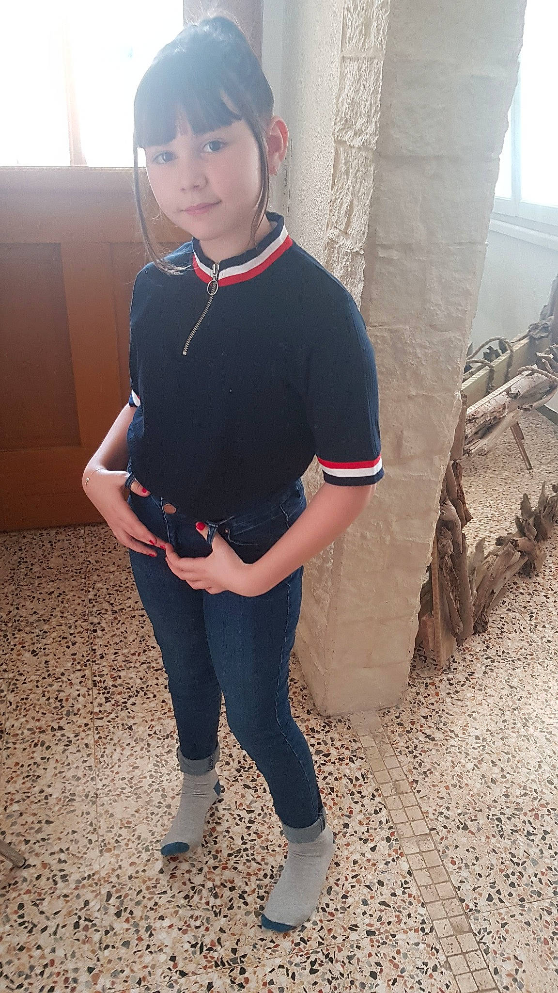 Anahé participe au concours pour gagner de l'argent avec cette photo : black_hair, child, clothing, fashion_accessory, footwear, person, shoe, sleeve, smile, t_shirt, uniform, waist