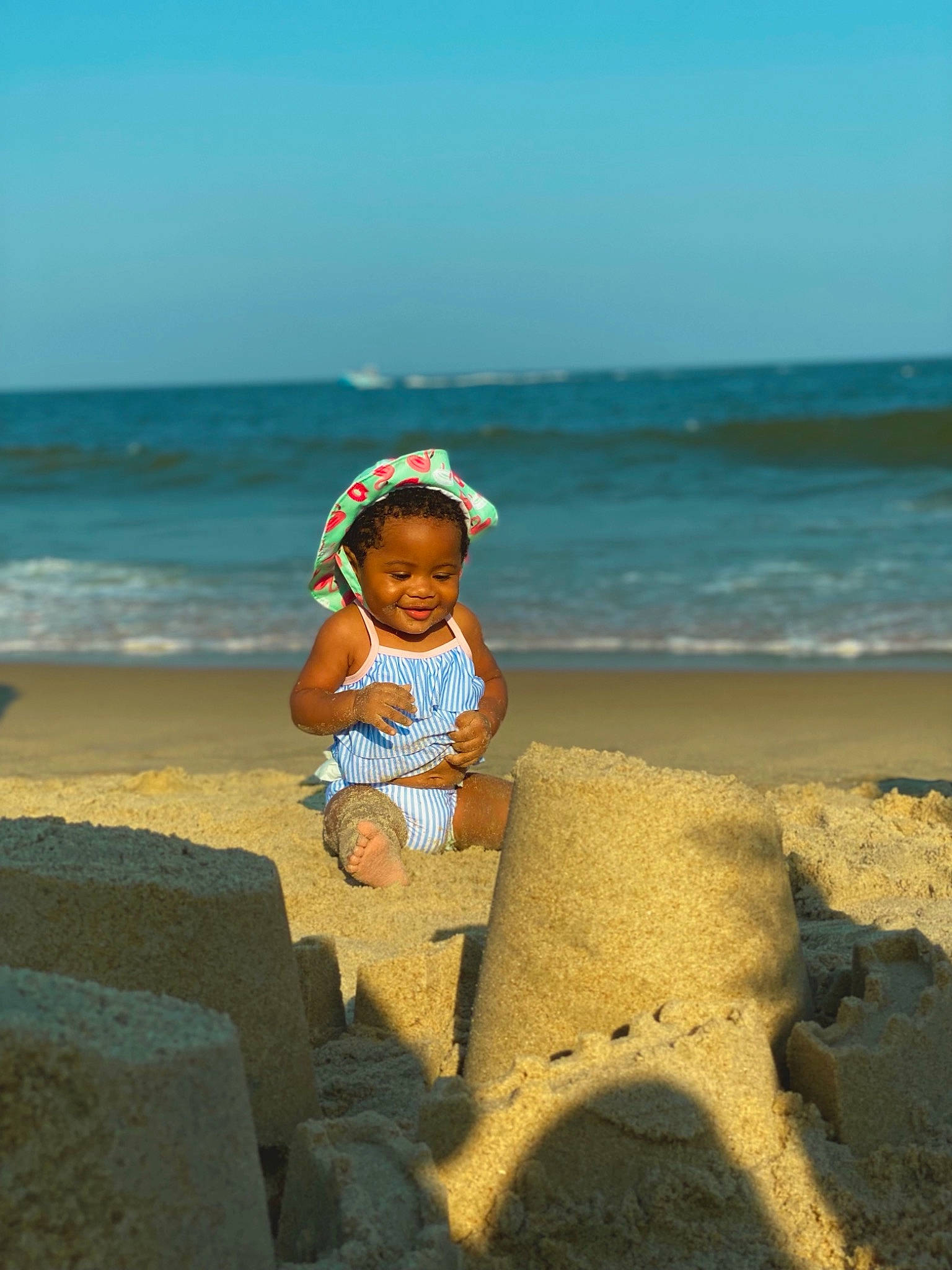 Amarah joined the competition — help win amazing prizes! baby, beach, coastal_and_oceanic_landforms, fun, happy, hat, holiday, horizon, joy, landscape, leisure, people_in_nature, people_on_beach, person, sand, sky, sun_hat, toddler, travel, water