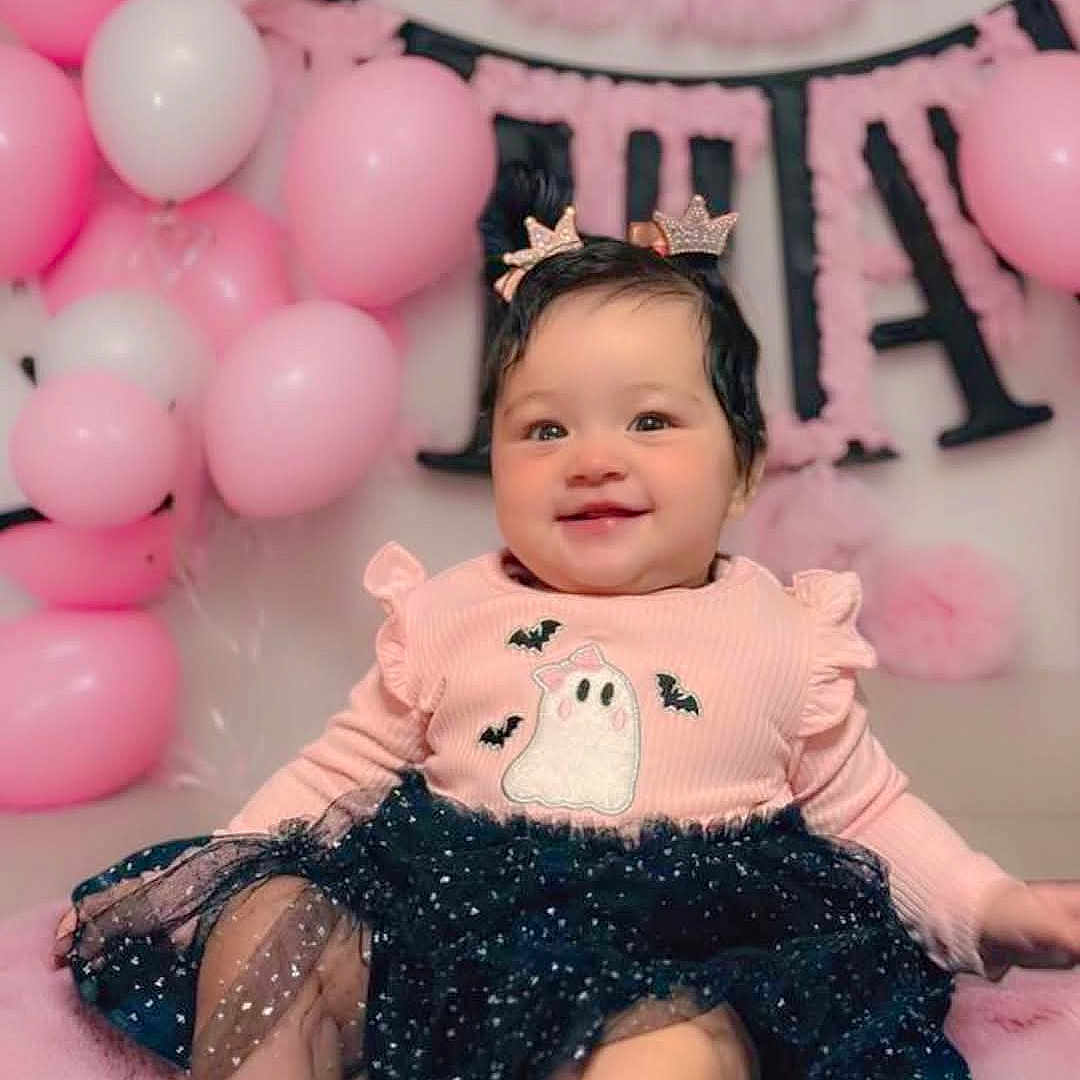 Nairobi is registered to the contest to win money with this photo: baby, balloons, bats, celebration, child, crown, cute, dress, ghost, girl, hair_clips, happy, indoors, party, pink, portrait, sitting, smiling, soft, tutu