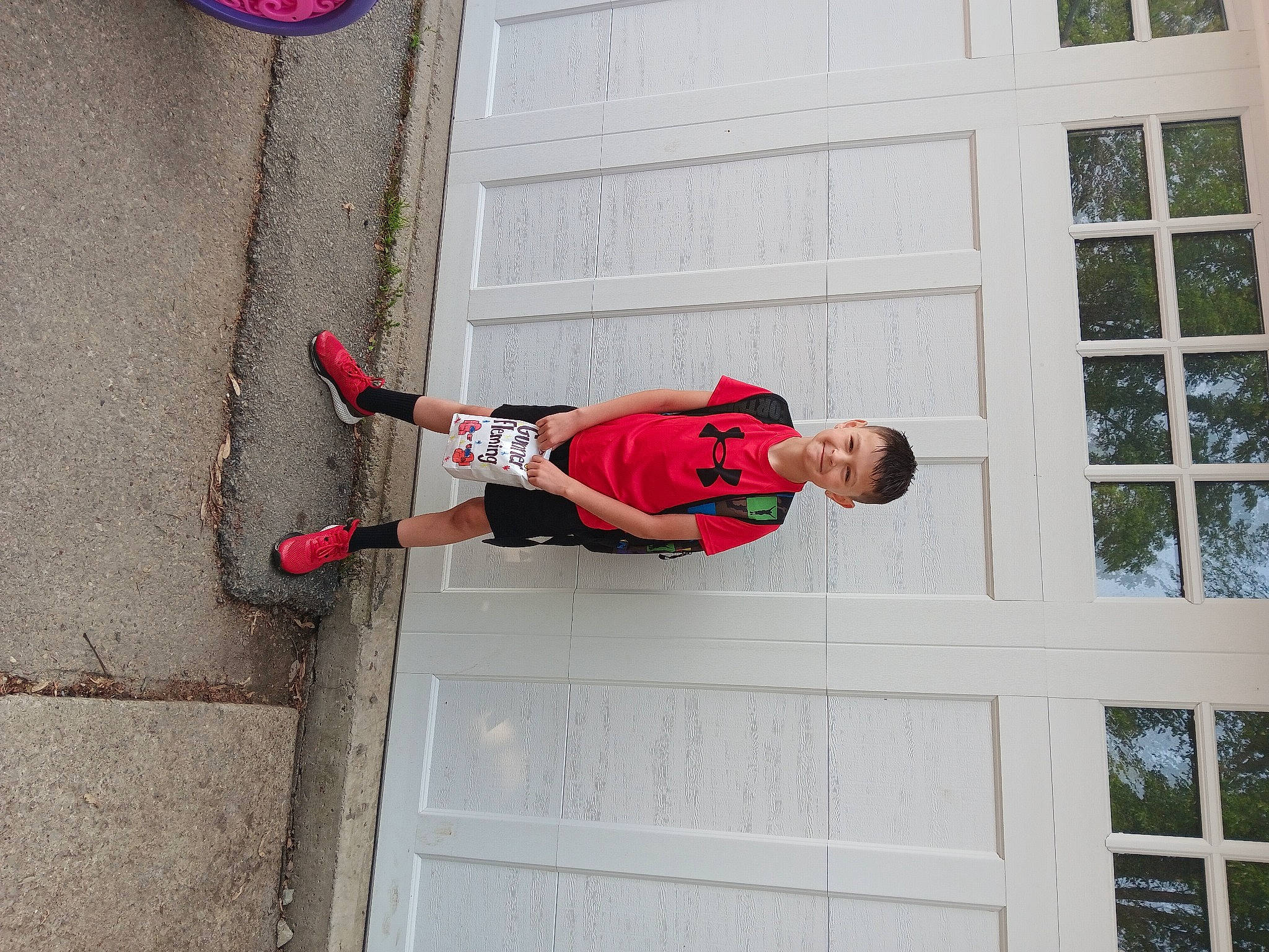 Gunner is registered to the contest to win money with this photo: adventure, building, carmine, cleanliness, concrete, door, elbow, facade, joy, outdoor_shoe, person, recreation, sash_window, smile, t_shirt, walking_shoe, window, wrist