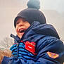 William participe au concours pour gagner de l'argent avec cette photo : blue_jacket, casual, child, cold_weather, daytime, face, happy, hat, hooded_jacket, jacket_patch, laughing, outdoor, person, pom_pom, portrait, puffy_jacket, sky, smiling, trees, winter_clothing