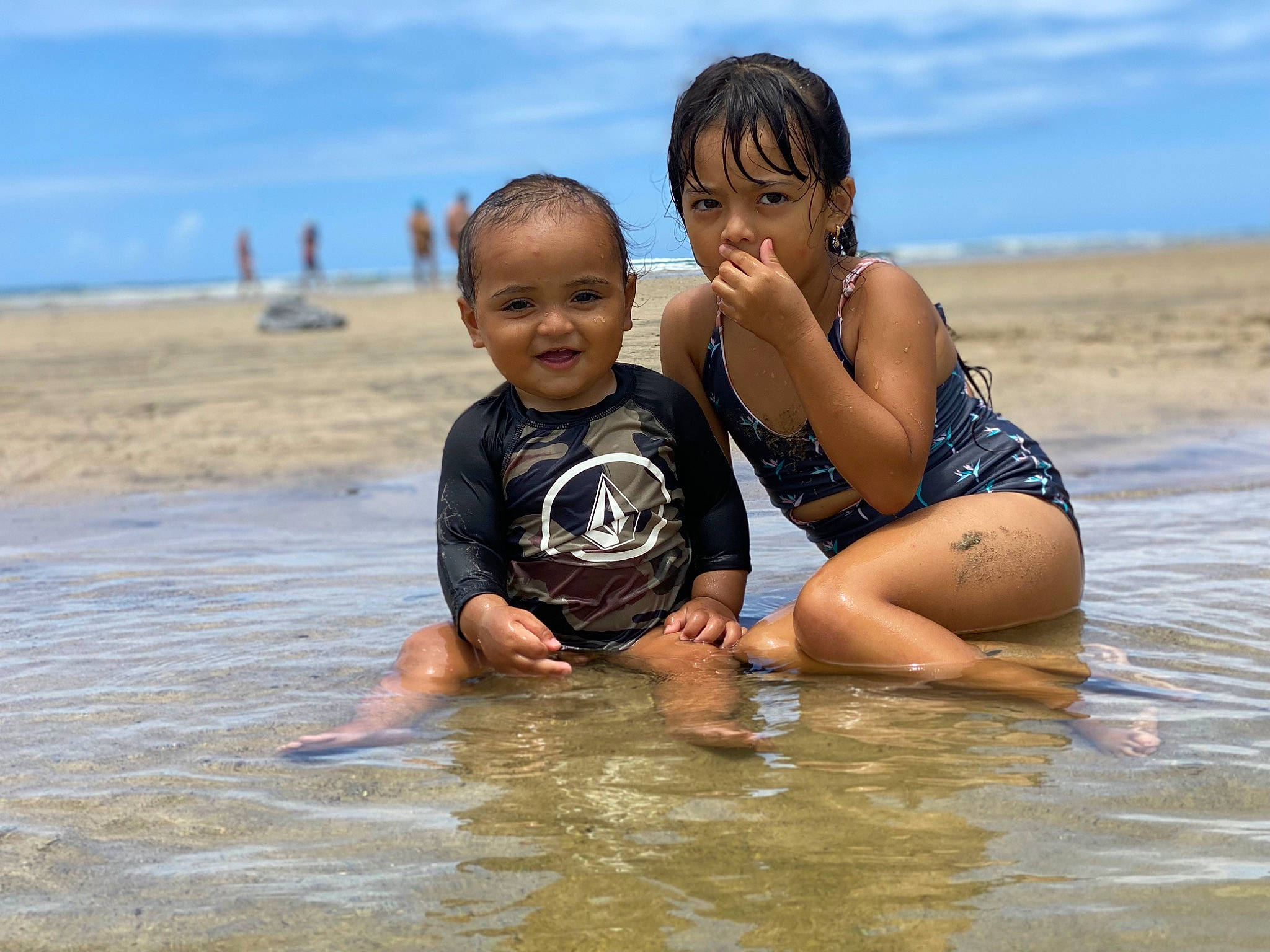 Nakoa is registered to the contest to win money with this photo: barefoot, beach, cloud, face, flash_photography, friendship, fun, gesture, happy, human_body, leisure, mammal, people_in_nature, people_on_beach, person, sky, smile, swimwear, toddler, vertebrate