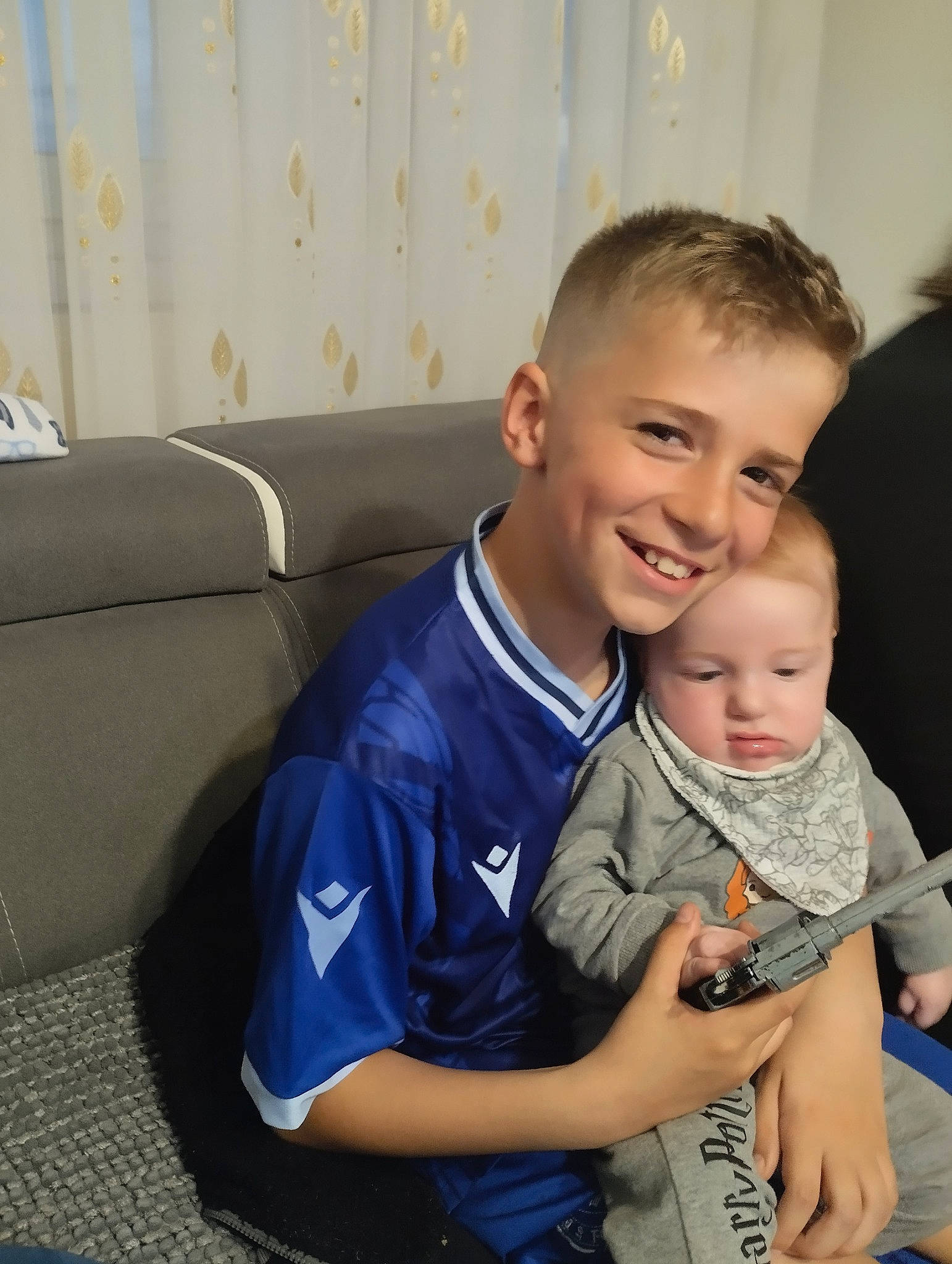 Ildan participe au concours pour gagner de l'argent avec cette photo : baby, child, comfort, couch, curtain, electric_blue, eye, face, family, fun, gesture, happy, joy, lap, laugh, person, room, sitting, smile, t_shirt