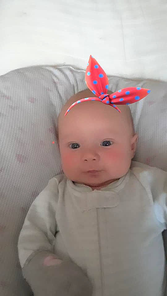 Karleigh is registered to the contest to win money with this photo: baby_products, cheek, child, eye, face, hair_accessory, head, headband, headgear, infant, nose, party_hat, person, pink, product, skin, smile, textile, toddler