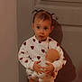 Judith participe au concours pour gagner de l'argent avec cette photo : child, toddler, doll, sweatshirt, heart_pattern, pigtails, indoors, door, shadow, big_eyes, portrait, standing, toy, hands, surprised_expression, cute, wall, skin_tone, soft_lighting, warm_filter