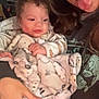 Emersyn is registered to the contest to win money with this photo: baby, blanket, person, glasses, tongue_out, indoor, holding, clothing, face, hand, curly_hair, smiling, sweatshirt, furniture, shelf, box, red_cup, home, cute, playful