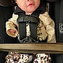 baby, car_seat, child, infant, safety_harness, clothing, pants, shirt, animal_print, seatbelt, cute, young_child, face, eyes, mouth, black_straps, fabric, patterned_pants, closeup, indoors