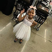 Nyla is registered to the contest to win money with this photo: accessories, child, city, clothing, costume, dress, face, female, footwear, girl, head, person, photography, portrait, road, sandal, shoe, skirt, street, urban