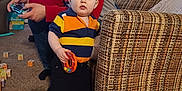Benjamin joined the competition — help win amazing prizes! toddler, man, video_game_controller, couch, toy, carpet, window, curtains, box, clothing, glasses, indoor, person, child, living_room, furniture, sock, basket, jeans, plush_toy