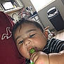 Kingsley is registered to the contest to win money with this photo: baby, child, indoor, kitchen, person, candy, teether, hand, face, chewing, striped_clothing, cabinet, sink, trash_bin, toy, floor, light, window, red_shirt, closeup