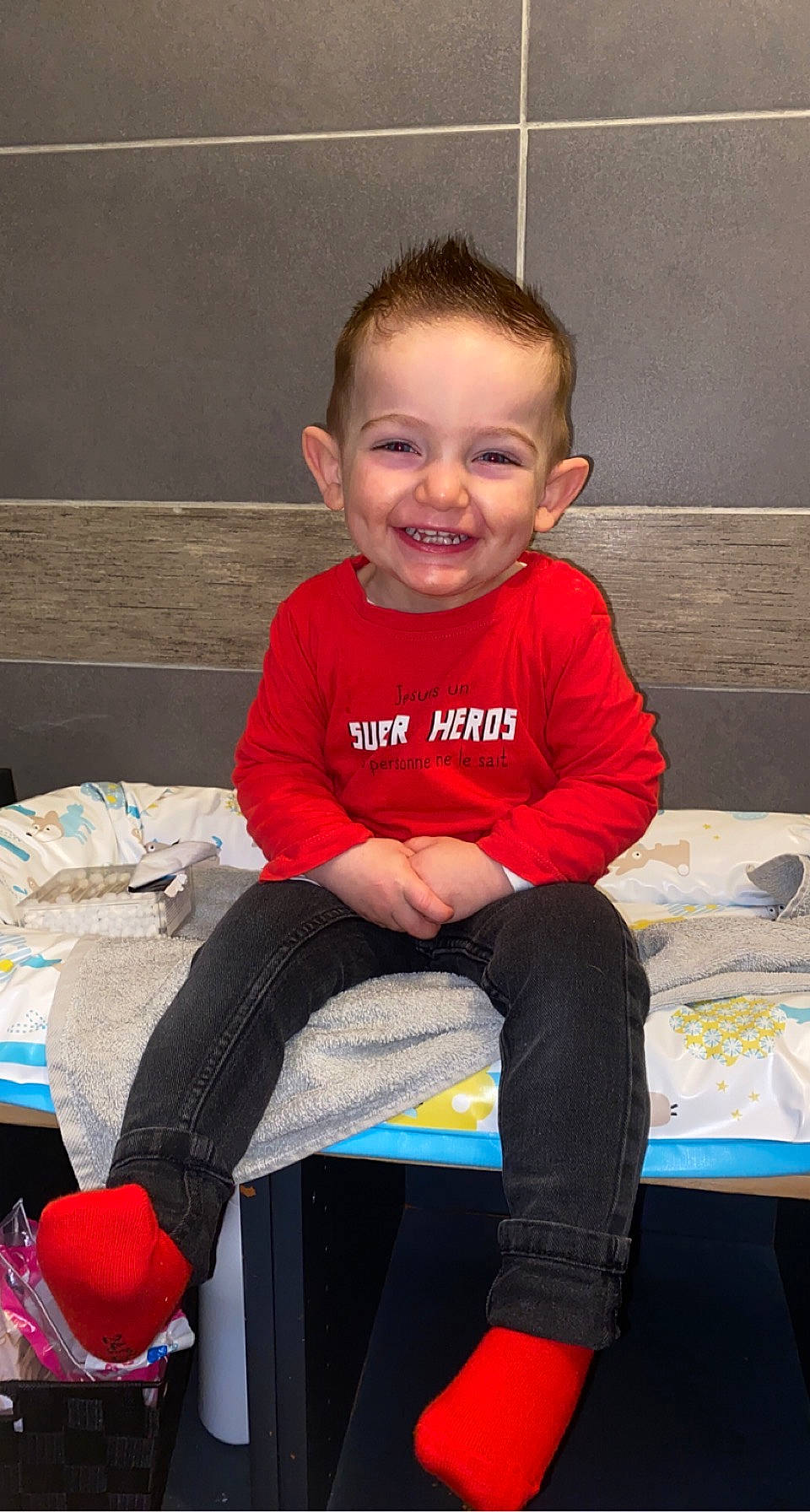 Mylio participe au concours pour gagner de l'argent avec cette photo : baby_toddler_clothing, child, facial_expression, fun, hairstyle, happy, head, human, human_body, joy, lap, leg, person, red, sitting, skin, sleeve, smile, standing, t_shirt