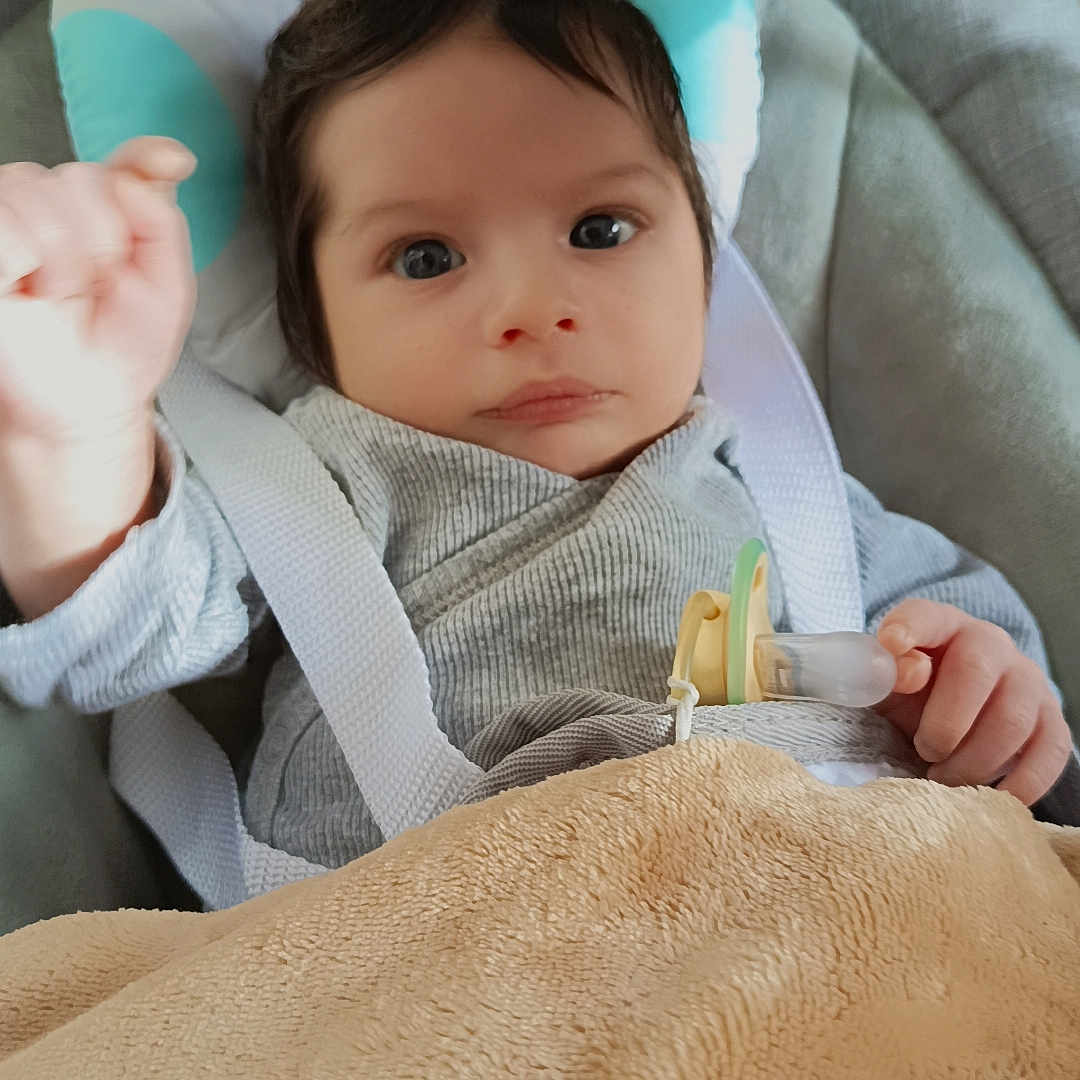 Yulian participe au concours pour gagner de l'argent avec cette photo : baby, baby_seat, blanket, child, clothing, comfort, cute, expression, face, headrest, indoors, infant, looking, pacifier, person, resting, soft, straps, toddler, young