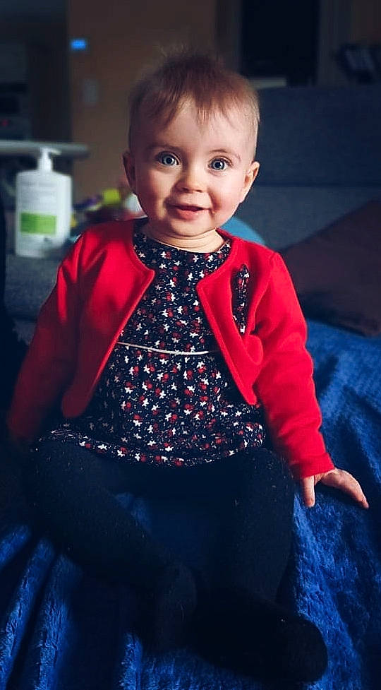 Romy participe au concours pour gagner de l'argent avec cette photo : baby_toddler_clothing, blue, cheek, chin, dress, eye, flash_photography, happy, head, iris, joy, lighting, lip, neck, organ, outerwear, person, skin, sleeve, smile