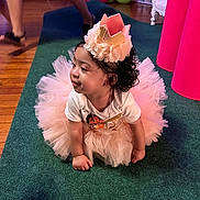 Delani is registered to the contest to win money with this photo: toddler, child, birthday, party, crown, tutu, pink, carpet, indoor, celebration, balloons, decorations, curly_hair, cute, crawling, floor, person, clothing, festive, happy