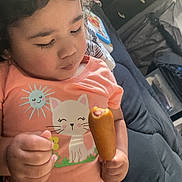 Angela-Moon joined the competition — help win amazing prizes! child, toddler, corn_dog, snack, pink_shirt, cat_graphic, curly_hair, diaper, hand, face, sleepy, indoor, bed, blanket, tablet, dresser, couch, portrait, eating, cute