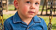 Parker joined the competition — help win amazing prizes! child, toddler, boy, portrait, face, eyes, short_hair, denim_shirt, clothing, sitting, swing, playground, outdoor, park, sunlight, trees, grass, playground_equipment, close_up, photography