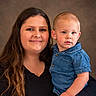 Parker is registered to the contest to win money with this photo: adult, baby, child, parent, portrait, family, face, smiling, serious_expression, denim, shirt, short_hair, long_hair, brown_hair, blue_eyes, indoor, studio, close_up, photography, person
