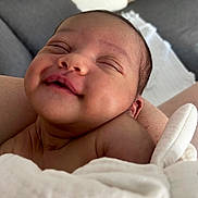 Zoé a rejoint le concours — aidez-le/la à gagner de superbes lots ! baby, newborn, smiling, close_up, blanket, wrapped, sleeping, face, skin, infant, cute, peaceful, indoors, soft, cozy, newborn_baby, person, child, head, portrait