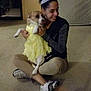 Ocho is registered to the contest to win money with this photo: child, companion_dog, costume, door, event, floor, flooring, footwear, formal_wear, fun, fur, happy, human_leg, knee, lap, room, sitting, smile, thigh, toy