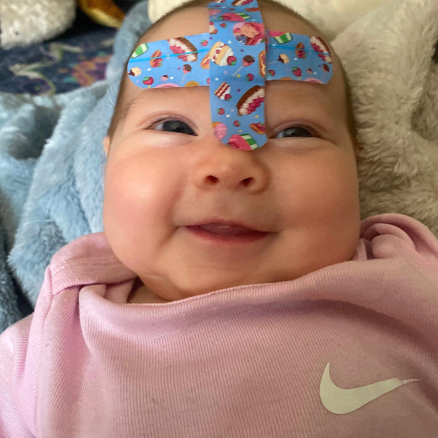Eva joined the competition — help win amazing prizes! baby, bandage, band_aid, face, smile, clothing, onesie, pink, blanket, soft, indoor, child, cute, head, person, happy, skin, infant, baby_girl, cozy