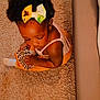 toddler, child, carpet, shoe, bow, hair_accessory, leopard_print, sitting, indoors, cozy, cute, baby, clothing, white_sock, floor, person, skin, head, arm, toy