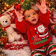 Ezra joined the competition — help win amazing prizes! baby, child, christmas_tree, christmas_ornament, holiday_lights, teddy_bear, snow, festive_clothing, red_hoodie, striped_pants, gift_boxes, candy_cane, holiday_decor, smiling, reaching_hands, indoors, celebration, happy, seasonal, festive