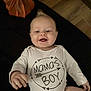 Nico is registered to the contest to win money with this photo: baby, infant, smiling, onesie, text_on_clothing, pumpkin, autumn, cute, happy, child, portrait, indoors, hand, head, floor, clothing, person, baby_girl, baby_boy, toddler