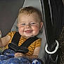 baby, child, car_seat, blue_eyes, blanket, striped_shirt, smile, happy, infant, cute, safety_harness, indoors, face, cheeks, person, blue_blanket, toddler, young_child, cozy, seat