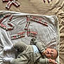 Erik joined the competition — help win amazing prizes! baby, infant, blanket, chocolate, kinder, candy, toy, clothing, white_socks, beige_outfit, lying_down, indoor, cute, child, playful, snack, food, sweet, person, expression