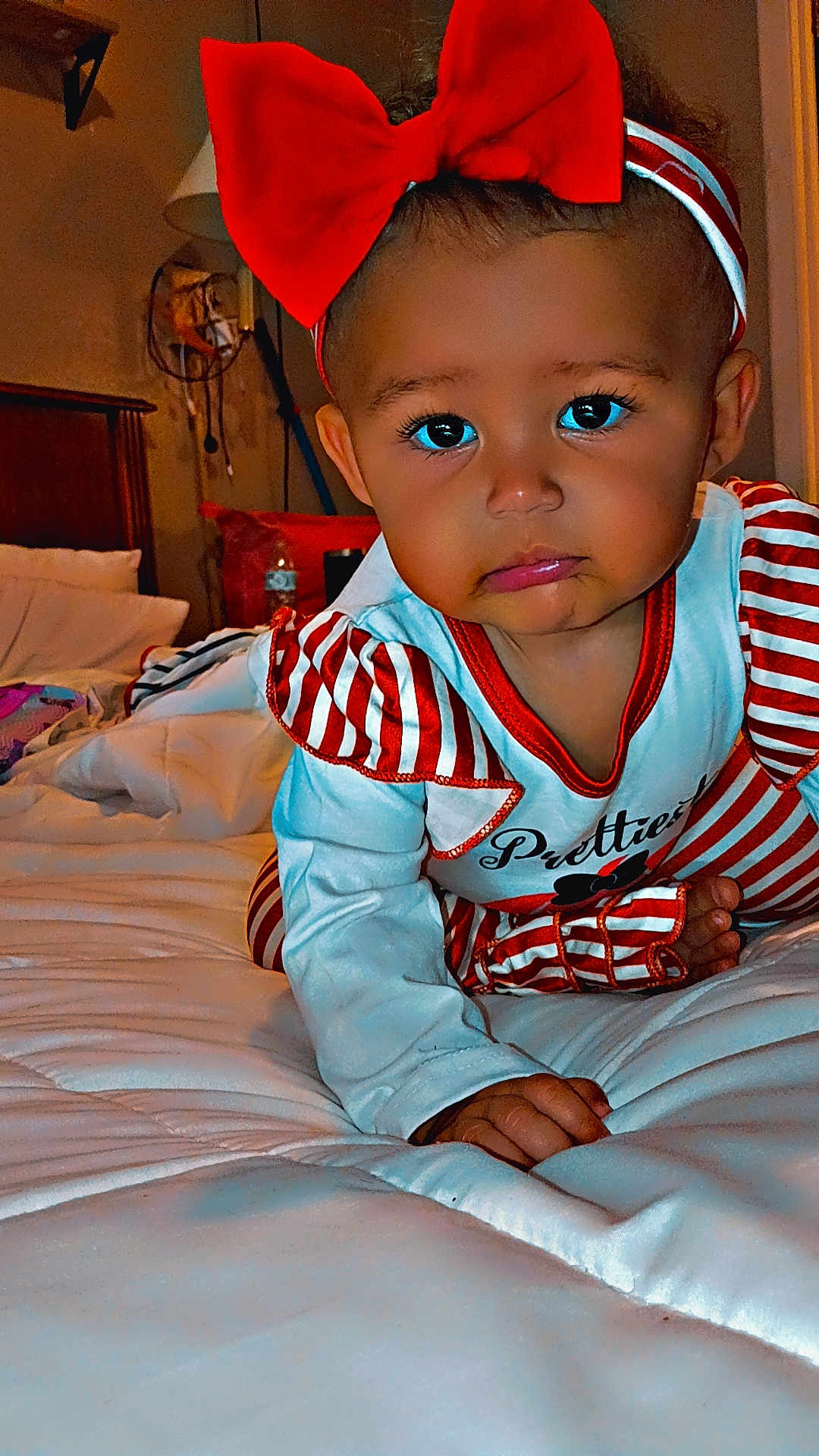 Theresa Amarii is registered to the contest to win money with this photo: baby, child, bed, red_bow, striped_clothing, crawling, indoor, lamp, pillow, blanket, headband, cute, infant, person, face, hand, foot, expression, room, furniture