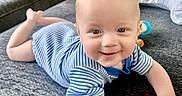 Leo joined the competition — help win amazing prizes! baby, blue_striped_clothing, bright, carpet, child, couch, cute, face, hand, happy, home, indoor, infant, lying_down, person, playful, smiling, soft_surface, toy, young_child