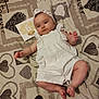 baby, blanket, card, child, closeup, cute, decor, fabric, headband, heart_pattern, indoors, infant, lying_down, portrait, small_feet, small_hands, smiling, soft_lighting, white_outfit, young_child