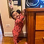 air_conditioner, butterfly_toy, child, curtain, dresser, face, furniture, hand, happy, indoor, mirror, onesie, pink_clothing, reflection, room, smiling, standing, toddler, toy, wooden_floor