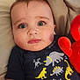 Grayson is registered to the contest to win money with this photo: baby, child, face, blue_eyes, hair, tshirt, dinosaur_print, plush_toy, red_toy, cushion, closeup, indoor, portrait, infant, cute, expression, lying_down, soft_lighting, skin, young_child