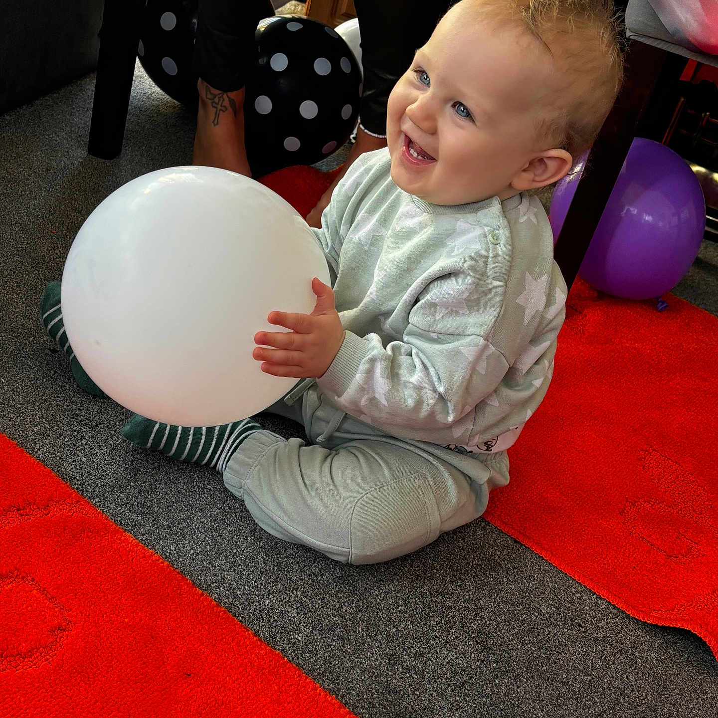 Leo is registered to the contest to win money with this photo: accessories, baby, bag, balloon, bodypart, chair, clothing, face, finger, footwear, furniture, hand, handbag, head, person, photography, portrait, shoe, sitting, sphere