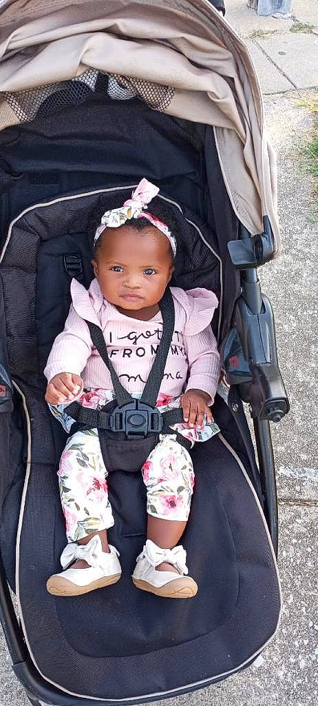 Amorah is registered to the contest to win money with this photo: baby, baby_carriage, baby_products, baby_safety, baby_toddler_clothing, bag, child, comfort, fashion_accessory, fun, grass, hairstyle, luggage_and_bags, magenta, pattern, person, pink, sitting, toddler, vacation