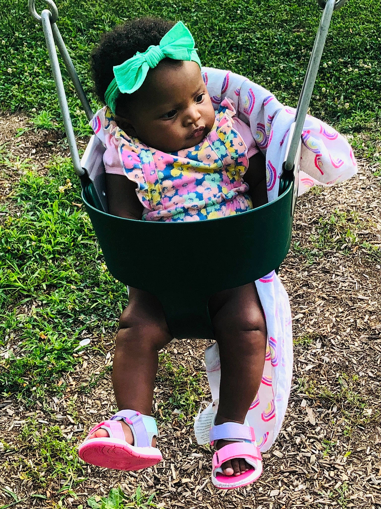 Amorah is registered to the contest to win money with this photo: baby, baby_products, baby_toddler_clothing, basket, child, facial_expression, fashion_accessory, fun, grass, human_leg, lawn, leisure, magenta, pattern, people_in_nature, person, pink, product, recreation, sitting