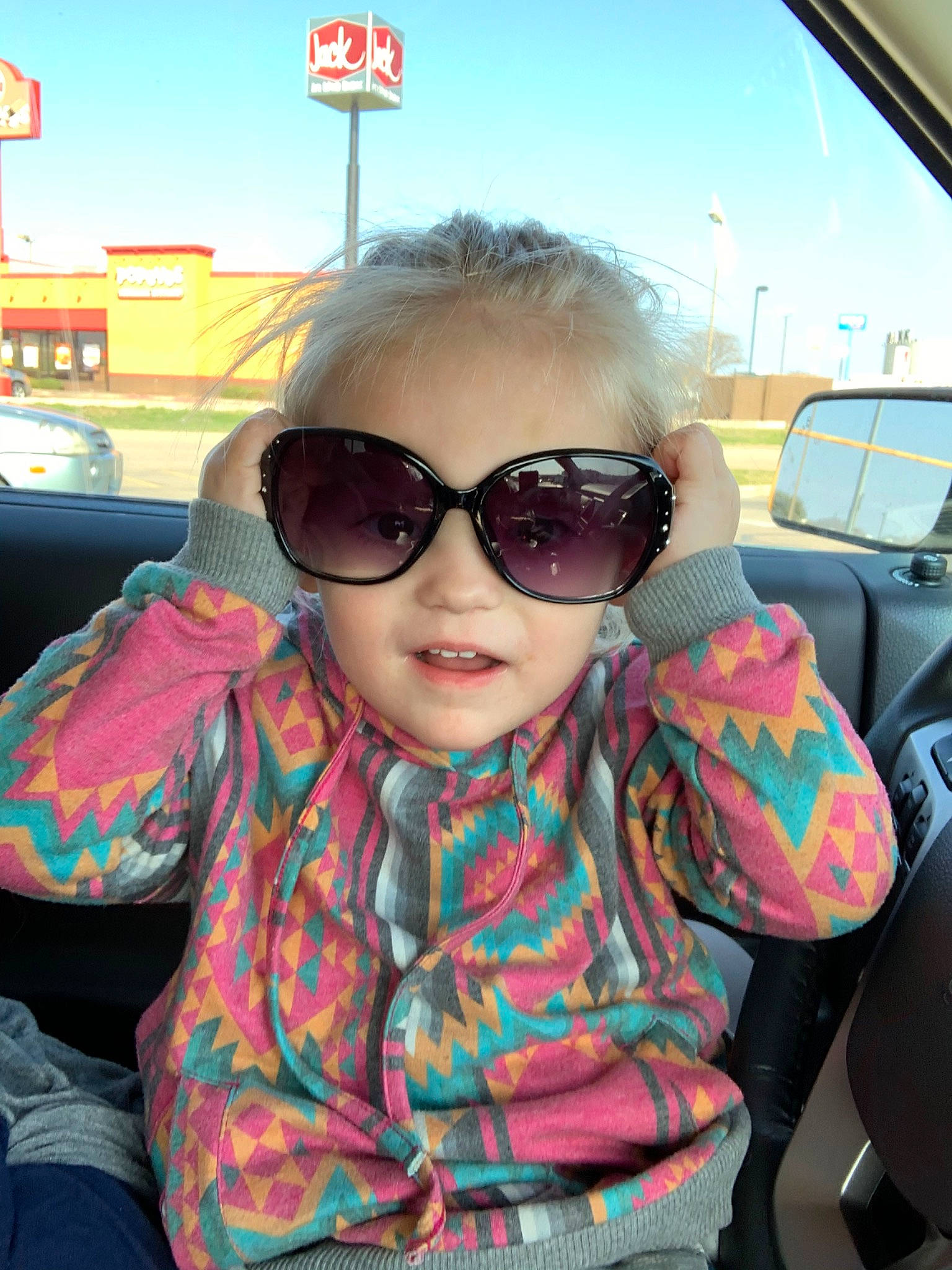 Taryn is registered to the contest to win money with this photo: black_hair, car, car_seat, child, chin, cool, eyewear, face, fun, glasses, head, headwear, lip, person, photography, pink, smile, sunglasses, vacation, vision_care